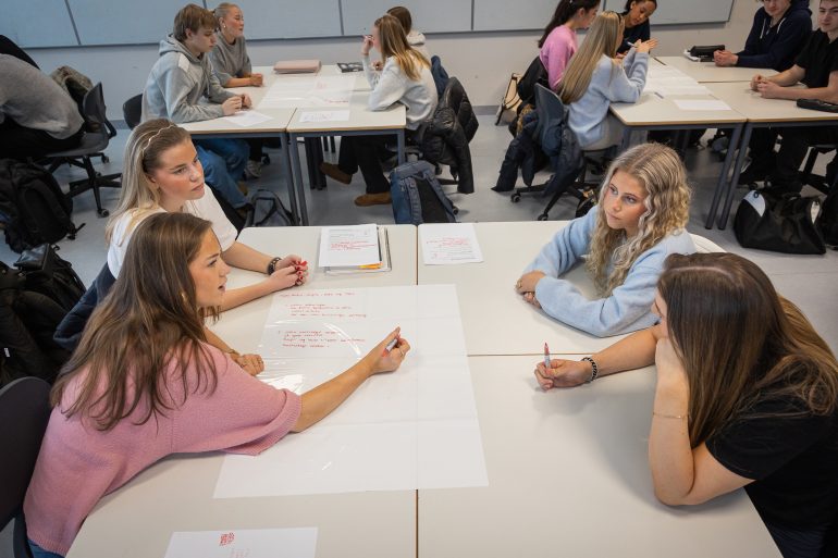 Bilde av fire ungdommer som arbeider med skoleoppgaver.