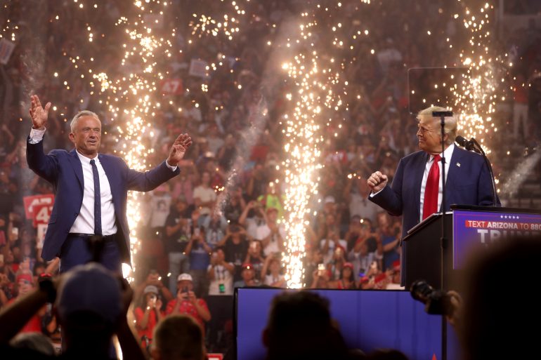 Bildet viser USAs president Donald Trump til høyre og helseminister Robert F. Kennedy til venstre på scenen under et valgkamparrangement.